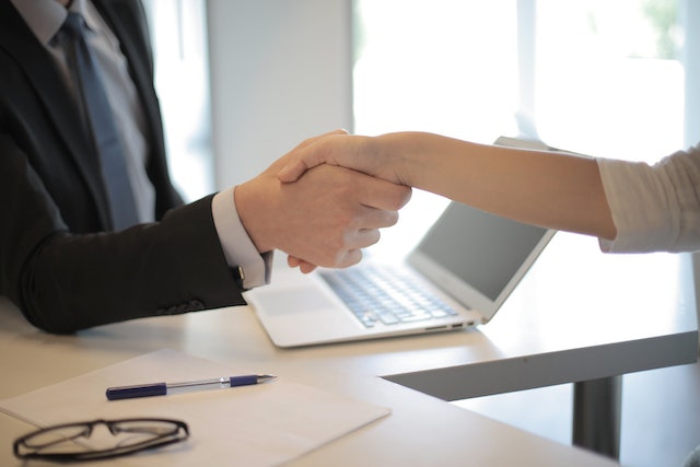 a property manager shakes a landlords hand
